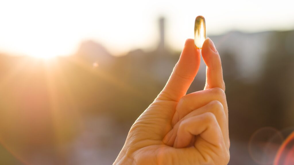 hand of a woman holding fish oil omega 3 capsules 2024 12 08 02 40 21 utc